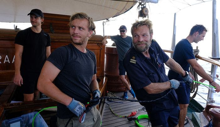 Forskerstudent Erlend Mundal og Jo Leif setter ut hydrofonen for å lytte etter hval. Foto: Isak Okkenhaug